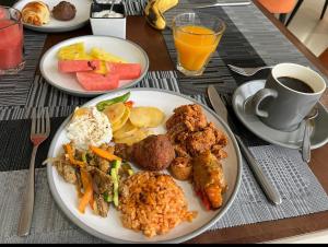 a table with plates of food and a cup of coffee at Keba Guest House - Addis Ababa in Addis Ababa