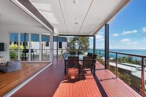 an open deck with a table and chairs on a balcony at DOLCE VILLA in Tangalooma