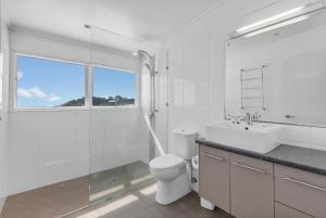 a white bathroom with a toilet and a sink at DOLCE VILLA in Tangalooma +18 photos