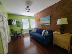 a living room with a blue couch and a table at 6 Bedroom 6 Bath Guesthouse on Duval Street in Key West