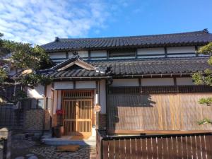 a house with a gate and a fence at はたご屋ちゅうべ in Taki