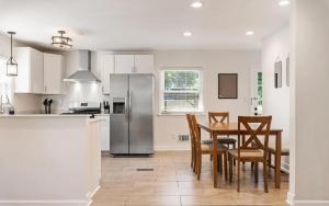 a kitchen with a table and chairs and a refrigerator at Charming 4-Bed Home with Modern Touches & Porch in Louisville