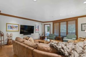 a living room with a couch and a tv at McCoy Peak 305 by East West Hospitality in Beaver Creek