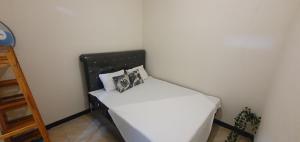 a small bedroom with a bed with white sheets and pillows at Homestay Syariah Studio A50 Panjalu in Panjalu