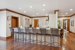 a kitchen with a bar with chairs around it at McCoy Peak 204 by East West Hospitality in Beaver Creek