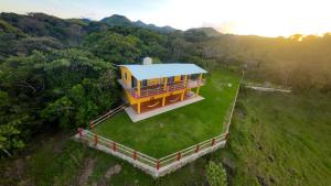 an overhead view of a house on a green field at Cascada el tucan in Montepio