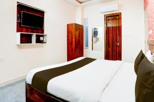 een slaapkamer met een bed en een tv aan de muur bij Hotel Aastha Shree Dham in Lucknow +12 foto's