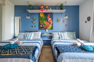 two beds in a room with blue walls at Casa Itzae La Luminaria Dog Friendly in San Miguel de Allende +116 photos