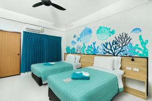 カロンビーチにあるTouch Sea Boutique Hotel&Bistroのアクアリウム壁画のあるホテルルーム内のベッド2台 +102枚の写真
