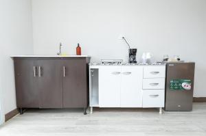 a kitchen with a white counter and a cabinet at D'Rosas Apartments in Santiago