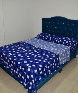 1 cama azul con edredón azul y blanco en Apartamento turístico portal del prado, en Santa Rosa de Cabal