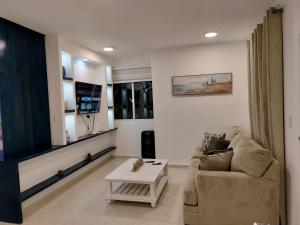 una sala de estar con un sofá y una mesa en Agréable appartement en rooftop, en La Cabirma