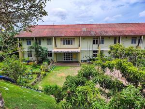 a house with a red roof and a yard at Caritas Rest in Galle