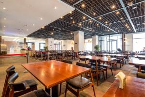 una sala da pranzo con tavoli e sedie in legno di 张家口云顶大酒店 a Chongli