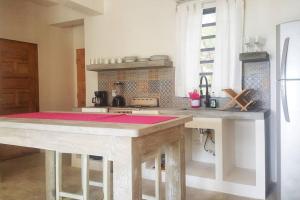 a kitchen with a table with a pink counter top at Babylon Beach Villa 2 in San Pedro