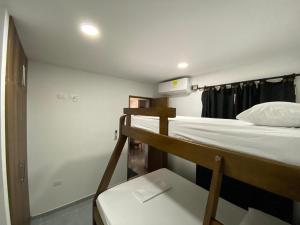 a dorm room with two bunk beds and a bench at Apartamento Villa Mary-Coveñas in Coveñas