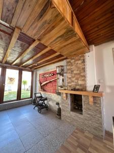 a living room with a stone fireplace and wooden ceilings at Sol de Huanchac in Huaraz