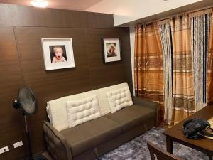 a living room with a couch and a baby picture on the wall at Makati Air Luxury Package - Laugh Sleep Brunch Surf 300 mbps Fast in Manila