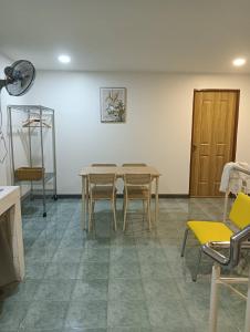 Habitación con mesa, sillas y puerta en Matinee House Hatyai, en Hat Yai