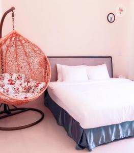 una camera con letto e sedia sospesa di Happy Fat B&B 寵物友善 a Città di Taitung