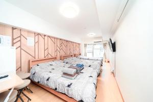 a bedroom with two beds and a desk at TOKYO ICHIBAN SHINJUKU in Tokyo