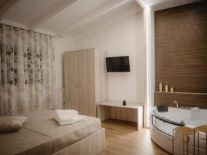 a bathroom with a tub and a bed and a television at Relais San Giovanni srls in Castellaneta +95 photos