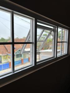 a window with a view of a house at Omame House Ciamis in Ciamis