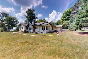 a house on a large grassy field with trees at Flagpole Point in Phelps