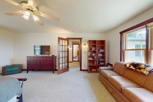 a living room with a couch and a ceiling fan at Flagpole Point in Phelps
