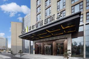 无锡Home2 Suites By Hilton Wuxi Huishan的顶部有标志的建筑物