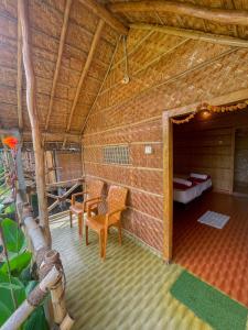 a room with a bed and chairs in a building at Blue Sky Cottages Hampi in Hampi