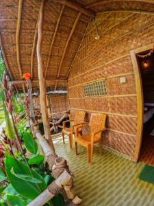 an outside view of a hut with chairs and a table at Blue Sky Cottages Hampi in Hampi