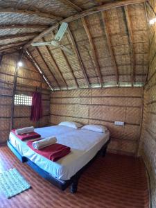 a bedroom with a bed in a straw hut at Blue Sky Cottages Hampi in Hampi