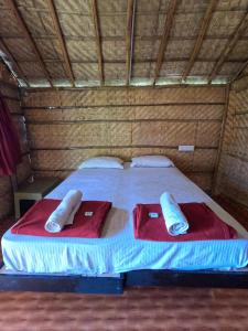 a bed with two red towels on top of it at Blue Sky Cottages Hampi in Hampi