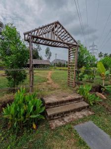 a small wooden structure with stairs in a field at Blue Sky Cottages Hampi in Hampi