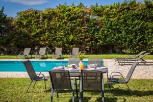 a table and chairs in front of a pool at Sun Villas in Sarlata