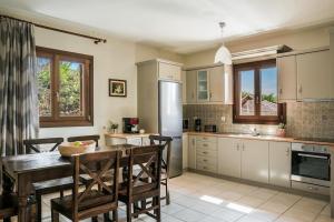 a kitchen with a wooden table and chairs and a kitchen with a sink at Sun Villas in Sarlata