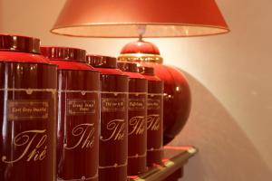 a group of red bottles sitting on a shelf under a lamp at Le Cavendish in Cannes