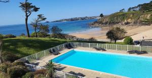 a large swimming pool next to a beach at Maison mer et piscine 3 nuits minimum in Loc-Maria-Plouzané