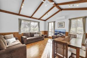 a living room with a couch and a table at Metung Holiday Villas in Metung