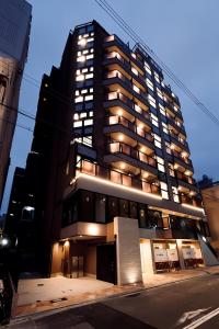 un edificio alto y negro con luces encendidas en 島内小宿, en Osaka