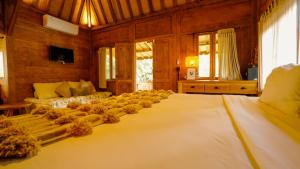 a bedroom with a large bed with flowers on it at Rumah Bambu Gladek Tiga in Uluwatu +28 photos