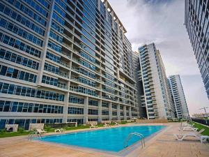 un gran edificio con una piscina y dos edificios altos en Luxury Holiday Home Just Minutes from Dubai's Global Village Your Perfect Getaway!", en Dubái
