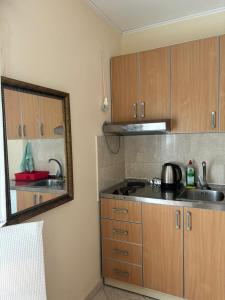 a kitchen with wooden cabinets and a sink and a mirror at Studio on the coast, with a view of the sunrise,free we-fi in Kotor