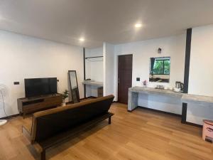 un soggiorno con un divano e una televisione di The Seaside Resort Koh Phangan a Wok Tum