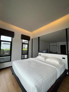 un grande letto bianco in una camera da letto con due finestre di The Seaside Resort Koh Phangan a Wok Tum Altre 72 foto