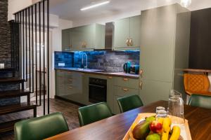 a kitchen with a table with a bowl of fruit on it at E-House Apartment Brasov in Noua