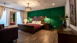 a bedroom with a green wall with a bed and a couch at E-House Apartment Brasov in Noua