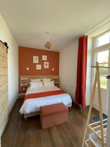 a bedroom with a bed and a red wall at Le Colibri - Domaine de la Houblette in Challans
