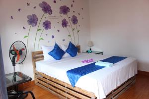 sypialnia z łóżkiem z fioletowymi kwiatami na ścianie w obiekcie Khai Yen Tam Coc Hostel w mieście Ninh Binh